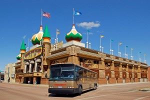 A brown bus parked in front of the Corn Palace.